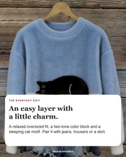 Lottie oversized sweater in light blue with editorial text about its relaxed fit, two-tone color block and sleeping cat motif.